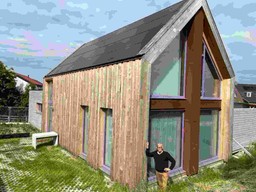 Levien de Putter leunend tegen het huis dat hij zelf heeft ontworpen en heeft laten bouwen in Zeeland