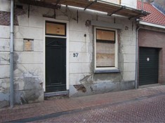 De voorgevel van een monumentaal pand in Kampen voordat Jelle Kapitein het gerestaureerd heeft nadat de ramen zijn verwijderd